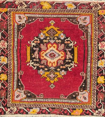 a close up of a red rug with a medallion design on it