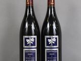 deux bouteilles de vin rouge posées sur une table en verre
