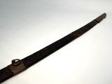 a close up of a long knife on a white surface