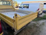 a yellow truck that is parked in the dirt