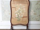 une chaise ornée d'un motif floral, placée devant un mur recouvert de papier peint