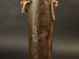 an image of an old metal bottle with rope handles