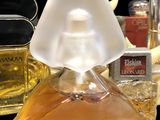 a bottle of perfume sitting on a table next to other bottles