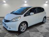 a picture of a white honda fit in a garage