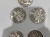 four different types of coins sitting on top of a white surface