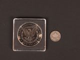 a close up of a coin and a small coin on a black surface