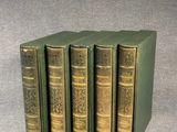 quatre livres verts empilés les uns sur les autres sur une table