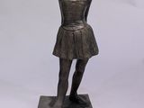 bronze statue of a girl in a dress on a marble base