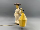 a figurine of a woman holding a bird cage