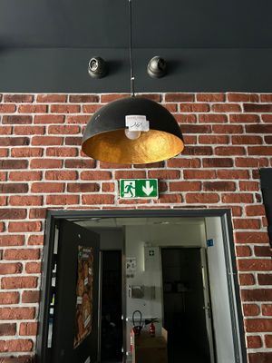 a brick wall with a light hanging from it ' s ceiling