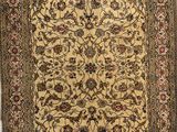 a gold and brown rug with a floral design on it