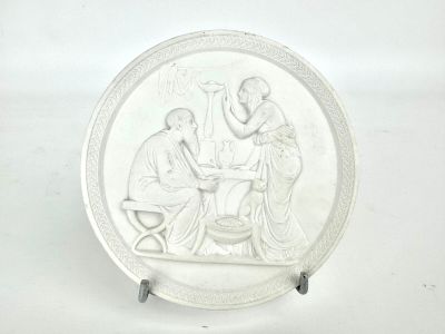 a white plate with a picture of a man and a woman sitting at a table