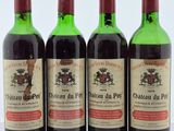 trois bouteilles de vin rouge sont alignées sur une surface blanche