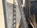 a ladder leaning up against a building next to a pile of wood