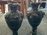 two black vases sitting on the floor in a room