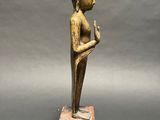 a small bronze statue of a person on a wooden block