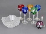 many different colored wine glasses and a bowl on the table