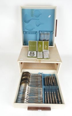une boîte en bois contenant de l'argenterie sur une surface blanche