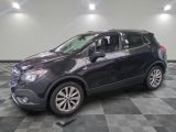 the buick suv is parked in the garage on a checkered floor