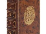 un vieux livre orné d'un emblème doré sur la couverture