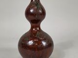 un vase brun posé sur une surface blanche