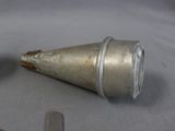 a small metal cone sitting on a table next to a remote control