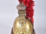 un vieux casque surmonté d'une plume rouge