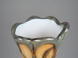 a close up of a vase on a table with a gray background