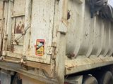 a dirty dump truck parked in front of a building