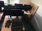 many computer screens and keyboards on the desk in this room