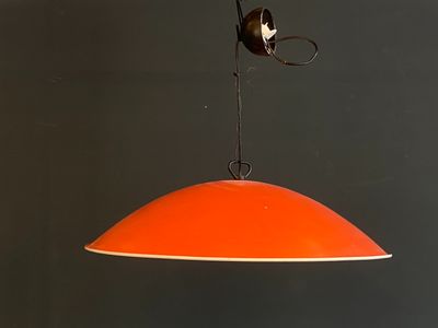 an orange light hanging from the ceiling with a bird on it