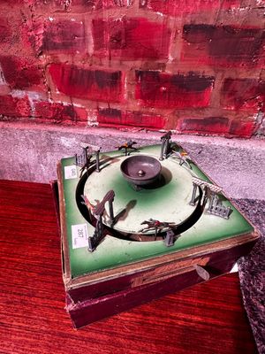 un vieux tourne-disque posé sur une table en bois, près d'un mur de briques