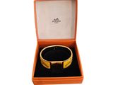 an orange box with a bracelet inside of it on a white surface
