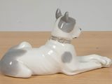 porcelain figurine of a dog laying down on a wooden table