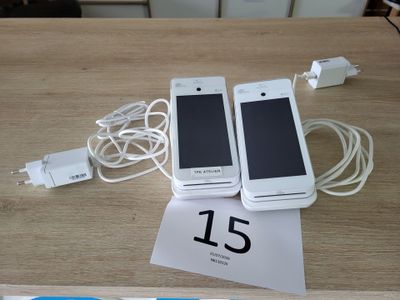 deux téléphones portables posés sur une table à côté d'un chargeur