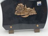 a black and gold plaque with a boat on it
