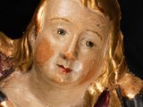 a statue of an angel holding a bird on a black background