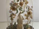 a glass dome with a statue inside of it on a table