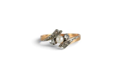 a close up of a gold ring with a pearl and diamonds