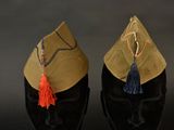 deux chapeaux ornés de pompons, posés sur une tête de mannequin