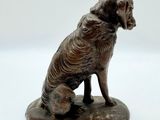 une statue représentant un chien assis sur un rocher