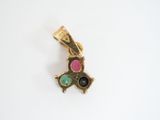 a close up of a gold charm with a pink, green, and black stone