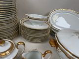 a lot of white and gold plates and cups
