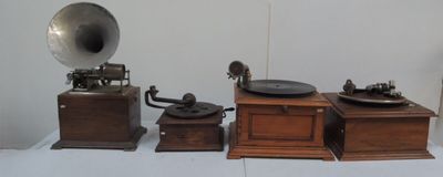 trois gramophones anciens exposés sur une table