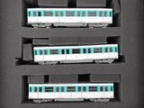 trois trains miniatures exposés dans une boîte noire