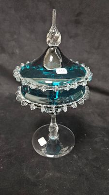 une image représentant un bol en verre sur lequel est posé un oiseau