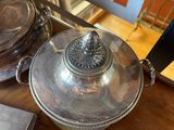 a silver plate with a lid on a wooden table
