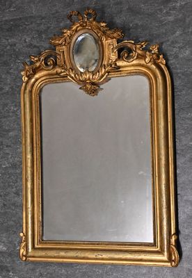 un miroir encadré d'or accroché au mur, sur lequel se reflète une image