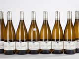 six bouteilles de vin sont alignées sur une surface blanche