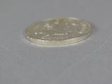 a small coin sitting on top of a white surface